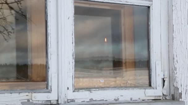In het venster houdt een man kaars — Stockvideo