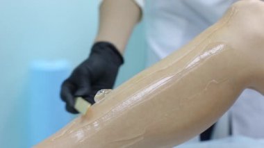 Güzellik, epilasyon, epilasyon, epilasyon ve insanlar kavramı - depilatory balmumu bacağı için uygulama aplikatör ile güzel kadın.