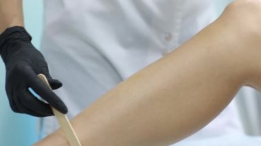 Güzellik, epilasyon, epilasyon, epilasyon ve insanlar kavramı - depilatory balmumu bacağı için uygulama aplikatör ile güzel kadın.