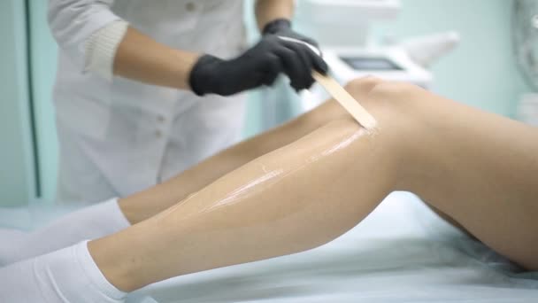 Bellezza, depilazione, epilazione, depilazione e concetto di persone - bella donna con applicatore che applica cera depilatoria alla gamba . — Video Stock