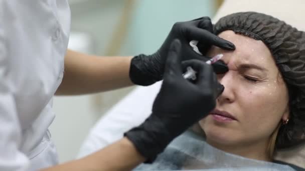 Cosmetologist γιατρός κάνει ενέσεις προσώπου ομορφιά για τον πελάτη της γυναίκας. Όμορφα Γυναικεία πρόσωπο και cosmetologists χέρια με σύριγγα. Αναζωογόνηση και ενυδάτωση. Κοσμετολογία έννοια στην κλινική. — Αρχείο Βίντεο