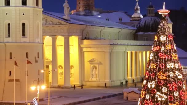 Riga, Letonia - 24 de diciembre de 2017: La gente y el mercado navideño festivo del árbol de Navidad en la plaza Dome en el centro de la antigua Riga, Letonia. Por la noche — Vídeos de Stock
