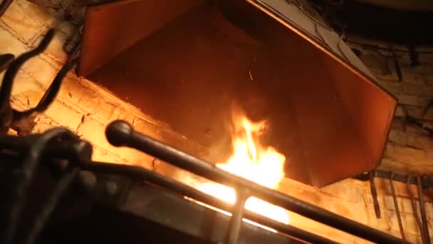 El herrero usa una vieja pala para avivar llamas dentro de la forja de carbón con el propósito de trabajar metal. . — Vídeo de stock