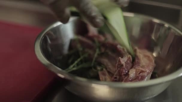 Hombre rebanando filete mignon a bordo en la cocina del restaurante. Chef preparando carne fresca para cocinar. Cocina moderna con fondo de hierbas y verduras — Vídeo de stock