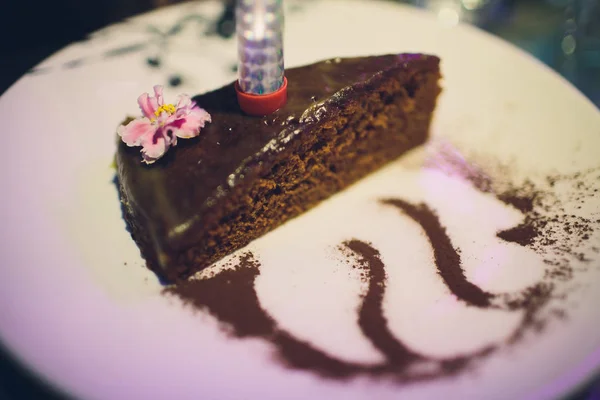 Delicious chocolate cake on plate on dark background. — Stock Photo, Image