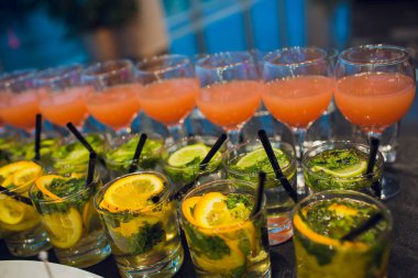 Güzel dekore edilmiş yemek masası. Hamburger, profiterol, salata ve soğuk atıştırmalıklarla. Masada çeşitli lezzetli atıştırmalıklar var..