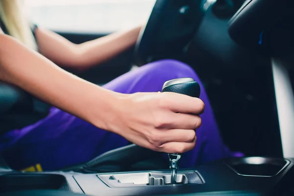 Mano de mujer sosteniendo un engranaje mientras conduce. como un miembro . — Foto de Stock