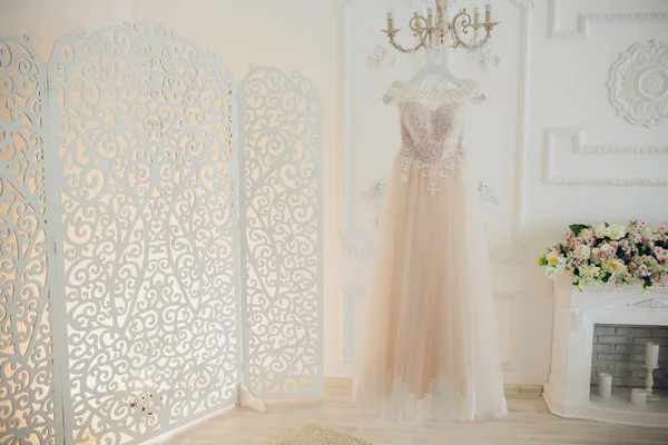 Hochzeitskleid hängt am Glanz im Hotelzimmer. — Stockfoto