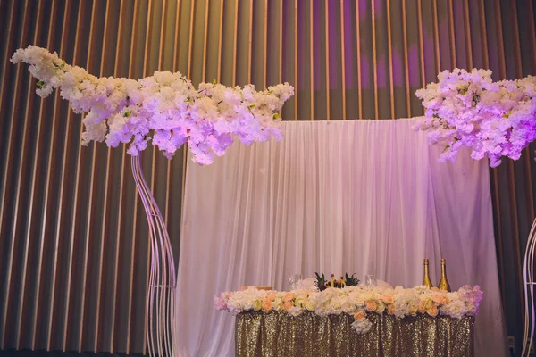 Detalles de la decoración de los novios y las novias mesa de boda en la fiesta de bodas. Decoración de tela rosa y flores. Bonbonnieres con miel para invitados . — Foto de Stock