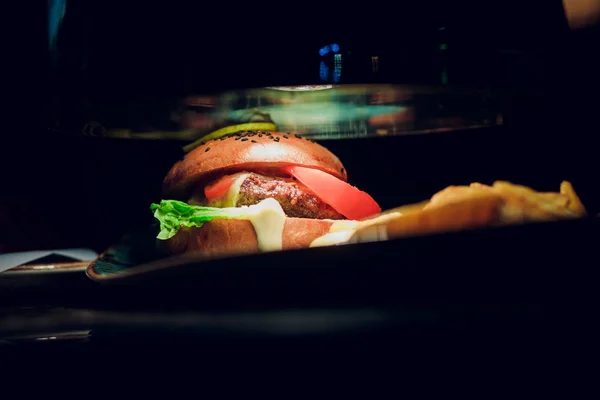 Cooking beef hamburger patty on an electric grill in a fast food restaurant in a close up view on meat — Stock Photo, Image