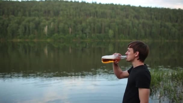 Закройте человека, пьющего пиво из стекла на открытом воздухе возле бассейна. Концепция алкоголя и отдыха . — стоковое видео