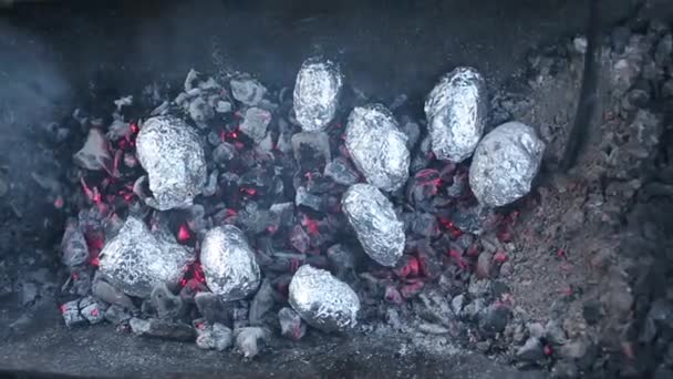 关闭篝火与橙色和黄色的火焰和柴火和烤土豆覆盖着铝箔, 滞后的巴默犹太节日篝火庆祝传统, 烤土豆在火 — 图库视频影像