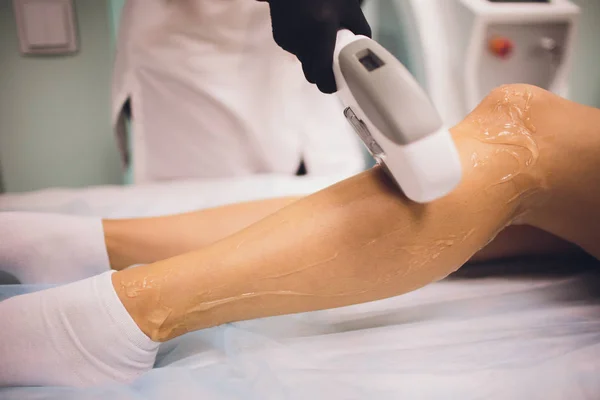 Hair removal cosmetology procedure from a therapist at cosmetic beauty spa clinic. Laser epilation. Cosmetology and SPA concept.