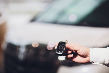 Araba anahtar closeup araba ile arka planda vererek Satış Yöneticisi.