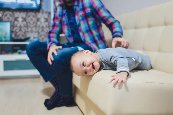 Feliz joven padre jugando con su hijita en el sofá . —  Fotos de Stock