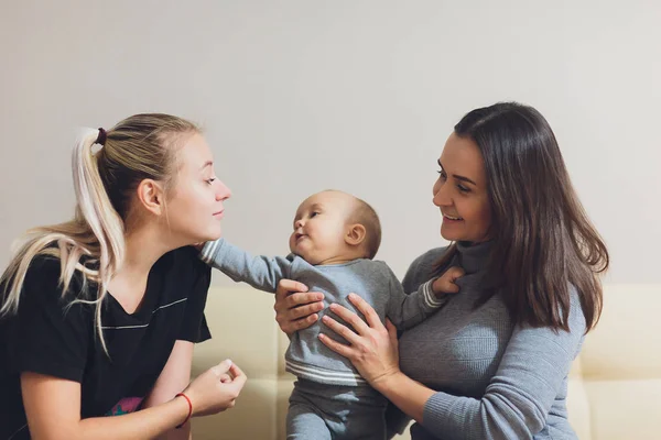 Gelukkige multi-etnische vrouwelijke paar met hun schattige babyjongen. — Stockfoto