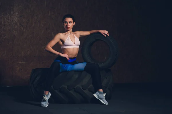 Spor salonunda fitness kadın saygısız tekerlek lastiği. Kadın atlet ile büyük bir lastik çalışma dışarı uygun. Arkadan görünüm. Bir güç yapıyor sporcumuz eğitim egzersiz. — Stok fotoğraf