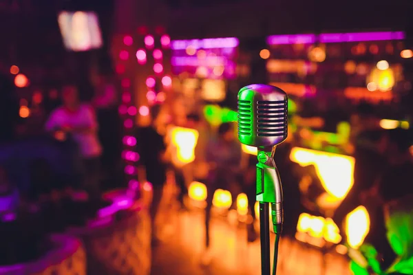 Retro microfoon tegen kleurrijke lichte restaurant achtergrond wazig. — Stockfoto