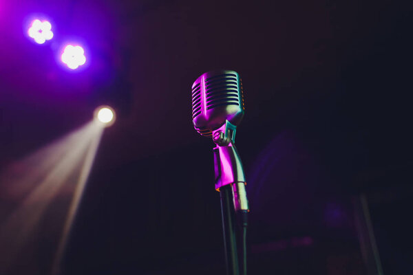 Retro microphone against blur colorful light restaurant background.