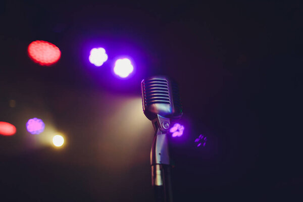 Retro microphone against blur colorful light restaurant background.