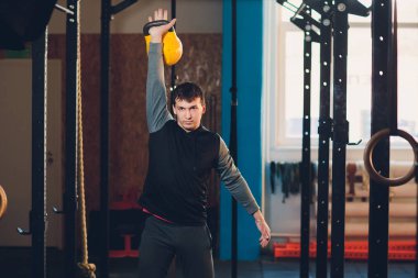 Genç adam kaldırma dumbbell ve kettlebell fitness Center.