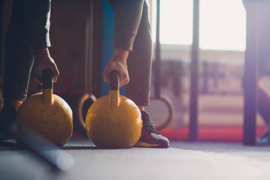 Su ısıtıcısı çan ile egzersizleri yapıyor Erkek atlet kadeh kırpılmış. Halter, güç kaldırma ve çapraz ekipman uyuyor. Spor, fitness kavramı.