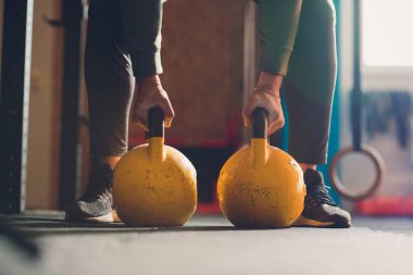 Su ısıtıcısı çan ile egzersizleri yapıyor Erkek atlet kadeh kırpılmış. Halter, güç kaldırma ve çapraz ekipman uyuyor. Spor, fitness kavramı.
