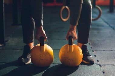 Su ısıtıcısı çan ile egzersizleri yapıyor Erkek atlet kadeh kırpılmış. Halter, güç kaldırma ve çapraz ekipman uyuyor. Spor, fitness kavramı.