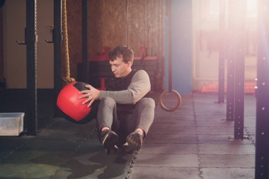 Karın egzersiz yerde yapan atletik erkek. Spor salonunda sağlık topu kullanılarak egzersiz yapan erkek.