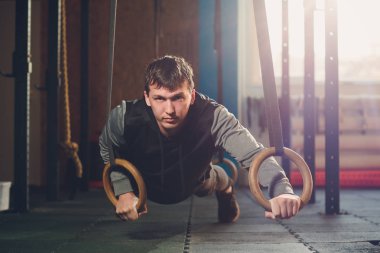 Jimnastik jimnastik halkaları üzerinde yoğun egzersiz yapan kas-up egzersiz atletik erkek.