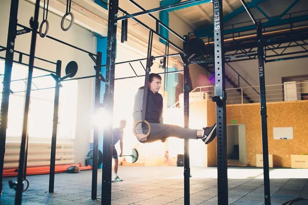 Ćwiczenia mięśni up athletic człowiek robi intensywnym treningu w siłowni na gimnastyczne. — Zdjęcie stockowe