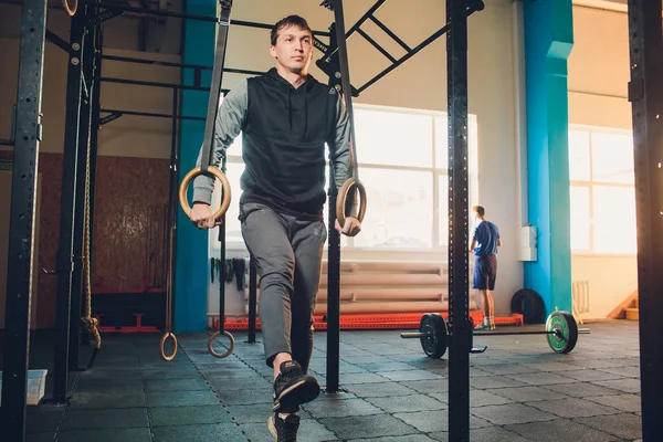 Мышечные упражнения спортсмен делает интенсивную тренировку в тренажерном зале на гимнастических кольцах . — стоковое фото