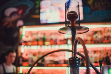Nargile bulanık bir bar bir bokeh ile karanlık bir arka plan üzerinde. Kopya alanı.