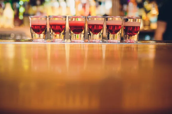 Bartender is pouring tequila into glass against the background of the bar. — Stock Photo, Image