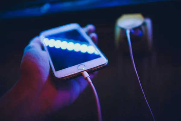 Hands of woman charging smartphone mobile phone device with cable and adapter.