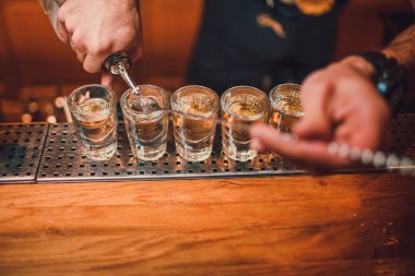 Barmen tekila çubuğunun arka planı cam içine yağıyor.