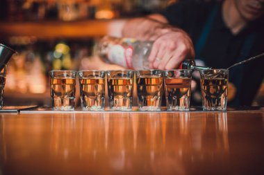 Barmen tekila çubuğunun arka planı cam içine yağıyor.