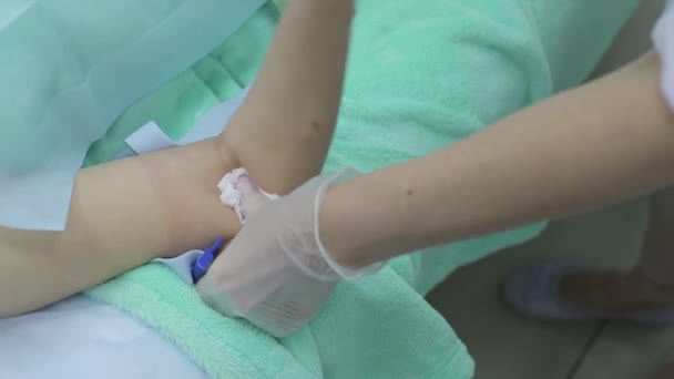 Enfermera recogiendo sangre de la vena del paciente que se acuesta en la cama médica en la clínica, mujer que se está probando de cerca — Vídeo de stock