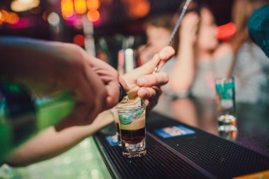 Barmen tekila çubuğunun arka planı cam içine yağıyor.