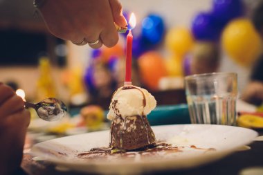 Bir kırmızı mum ve renkli sprinkles ile doğum günü kek.