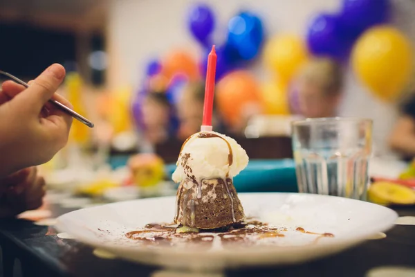 Gâteau d'anniversaire avec une bougie rouge et des paillettes colorées . — Photo