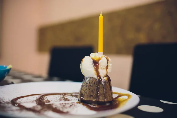 Cupcake de aniversário com uma vela vermelha e polvilhas coloridas . — Fotografia de Stock