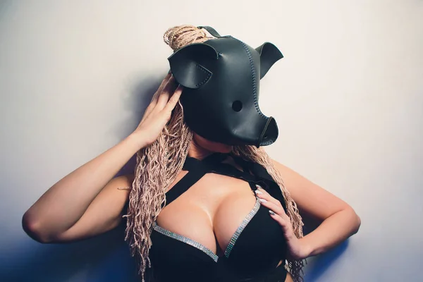 Swine mascot costume dance striptease woman in black leather pig mask.