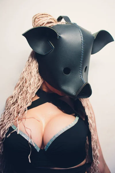 Swine mascot costume dance striptease woman in black leather pig mask.