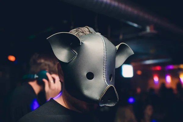 Seorang pria perusahaan dalam setelan kotor kotor mengenakan masker babi hitam di latar belakang jahat gelap, difoto dengan pencahayaan sinematik murung. Perusahaan kotor jahat babi . — Stok Foto