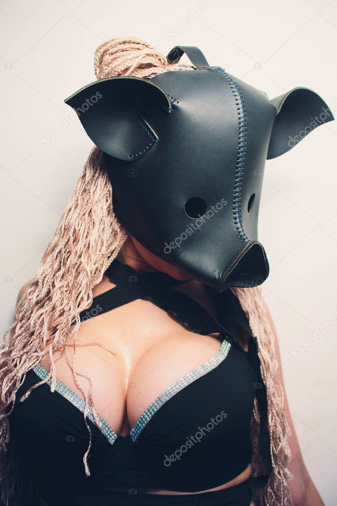 Swine mascot costume dance striptease woman in black leather pig mask.