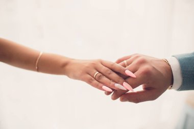 Elele, onların weddingbands gösterilen yeni evliler. Beyaz arka plan.