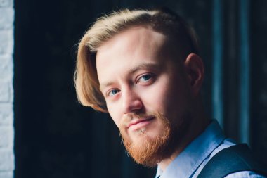 Nadir görünümü ile sarışın genç adam portresi beyaz t gömlek giyer.