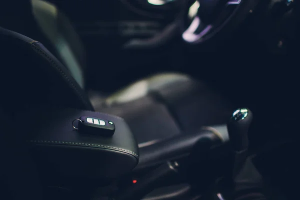 Primer plano dentro del vehículo de encendido inalámbrico por llave. Llave del coche a distancia en interior de cuero perforado negro. Detallando el coche. Las llaves cierran . — Foto de Stock