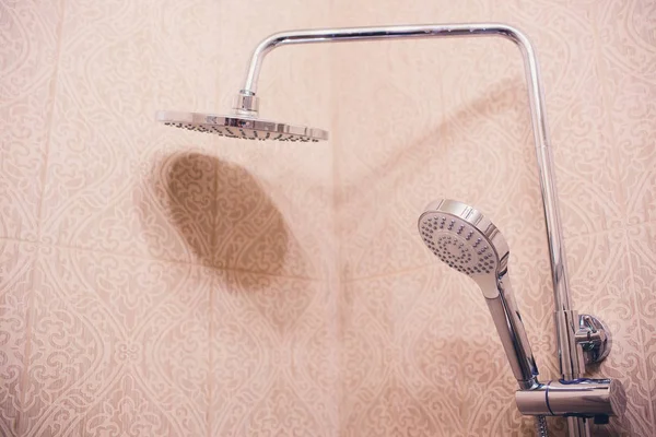 В ванной комнате, открытый душ смеситель прикреплен к настенной кронштейн, тонированное черно-белое изображение, вертикальный формат . — стоковое фото